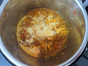 finishing the butternut squash lentil curry with some coconut milk for a creamy texture