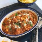 cauliflower tikka masala served in a blue bowl with saffron rice