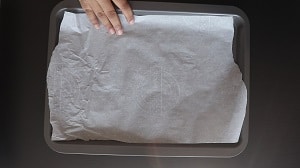 Line a baking tray with parchment paper. Parchment paper prevents the frozen strawberries from sticking to the tray