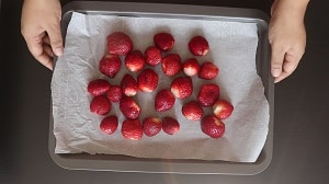 place the clean, dry and hulled strawberries on baking tray for freezing