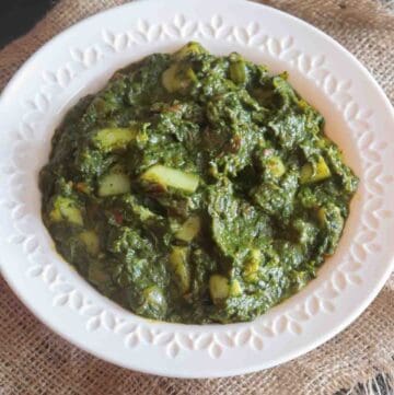 Saag Aloo or Indian Potato Spinach curry served in a white bowl