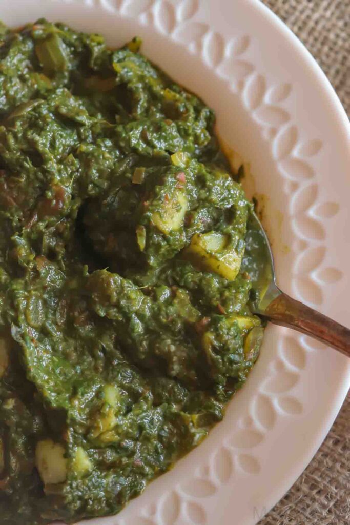 Close up image of saag aloo or potato spinach curry