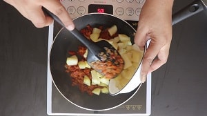 adding soft boiled potatoes to the onion tomato curry base