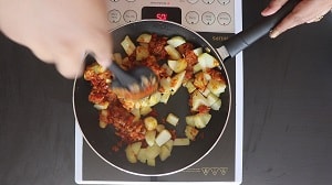 coating the curry base with potatoes